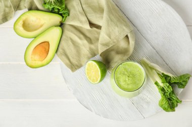 Masada bir bardak sağlıklı meyve püresi ve malzeme var.