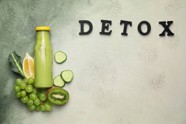 İçi malzemelerle dolu sağlıklı bir içecek ve masada DETOX yazıyor.