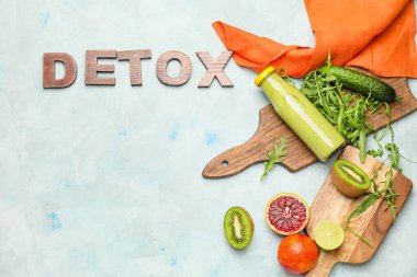 İçi malzemelerle dolu sağlıklı bir içecek ve masada DETOX yazıyor.