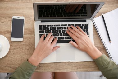 Evde online öğrenim için dizüstü bilgisayar kullanan olgun bir kadın