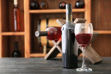 Masada bir şişe ve bir bardak şarap.