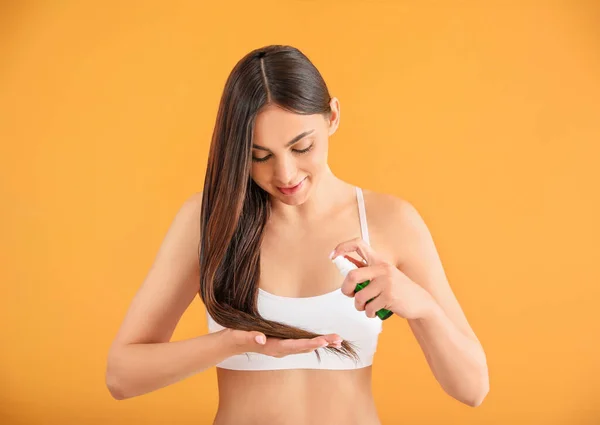 Jeune Femme Utilisant Des Cosmétiques Pour Les Cheveux Sur Fond — Photo