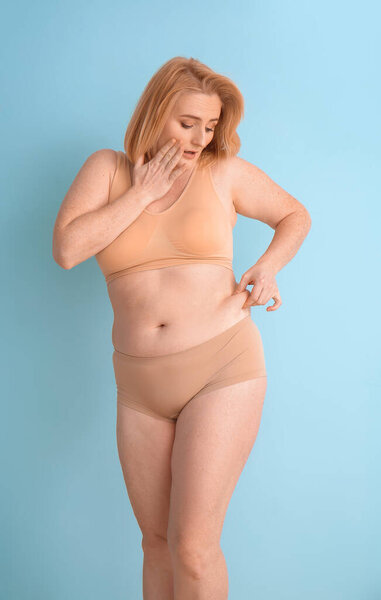 Проблемы с лишним весом женщины на цветном фоне
