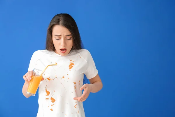 穿着肮脏衣服的年轻女子喝着彩色背景的果汁 — 图库照片