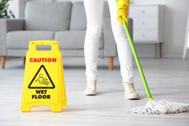 Genç bir kadın odayı paspaslıyor.