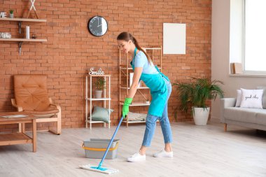 Genç bir kadın odayı paspaslıyor.