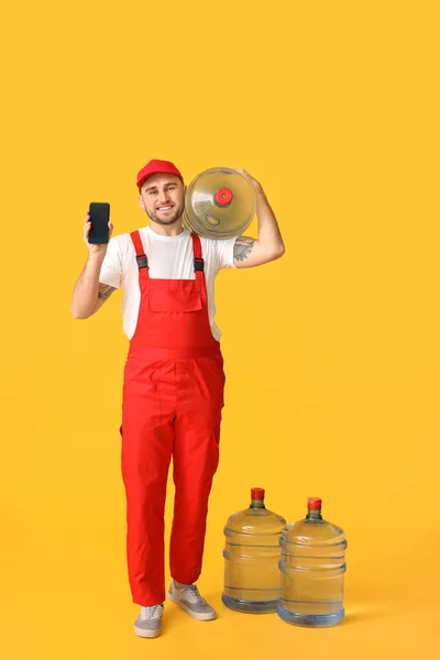 Delivery Man Bottles Water Mobile Phone Color Background — Stock Photo, Image