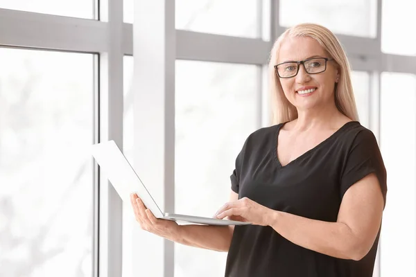 Portret Van Volwassen Zakenvrouw Met Laptop Buurt Venster Kantoor — Stockfoto