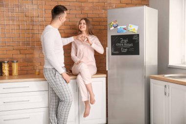 Mutfakta buzdolabının yanında mutlu bir çift.