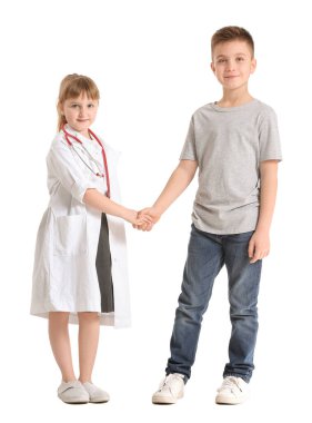 Hasta beyaz arka planda el sıkışan sevimli küçük bir doktor.