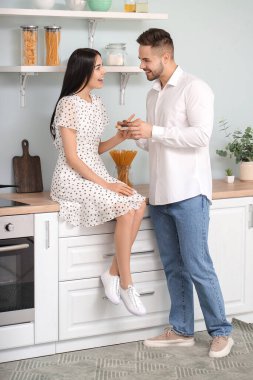 Güzel genç bir çift mutfakta çikolata yiyor.