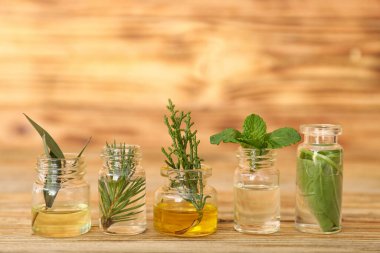 Ahşap arka planda farklı temel yağları olan şişeler.