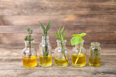 Ahşap arka planda farklı temel yağları olan şişeler.