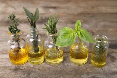 Ahşap arka planda farklı temel yağları olan şişeler.