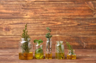 Ahşap arka planda farklı temel yağları olan şişeler.