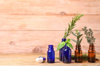 Ahşap arka planda farklı temel yağları olan şişeler.