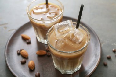 Gri arka planda bir bardak lezzetli buzlu kahve.