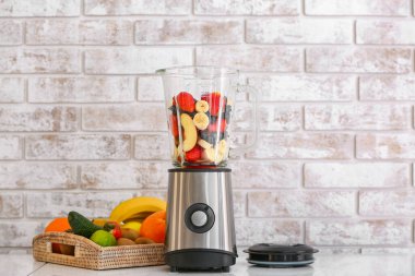 Mutfak masasında sağlıklı meyve püresi için modern blender ve malzemeler