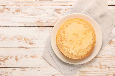 Beyaz ahşap arka planda lezzetli bir blini.