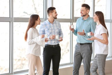 İş arkadaşları ofiste kahve içiyor.