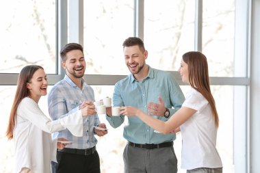 İş arkadaşları ofiste kahve içiyor.