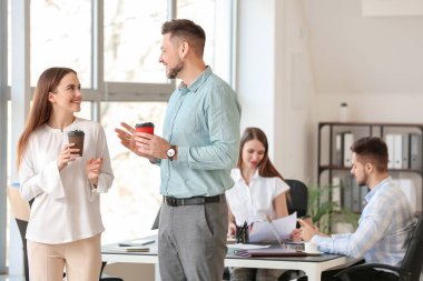 İş arkadaşları ofiste kahve içiyor.