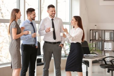 İş arkadaşları ofiste kahve içiyor.