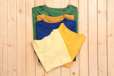 Ahşap arka planda farklı tarz tişörtler.