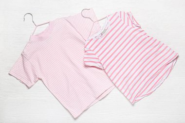 Beyaz ahşap arka planda farklı tarz tişörtler.