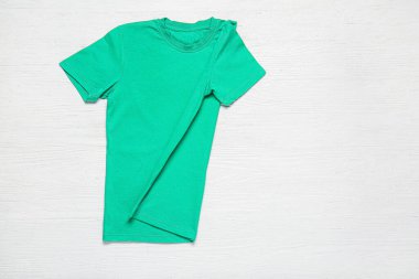 Beyaz ahşap arka planda şık tişörtler