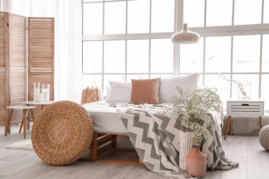 İçinde bahar çiçekleri olan güzel, modern bir yatak odası.