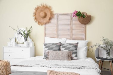 İçinde bahar çiçekleri olan güzel, modern bir yatak odası.