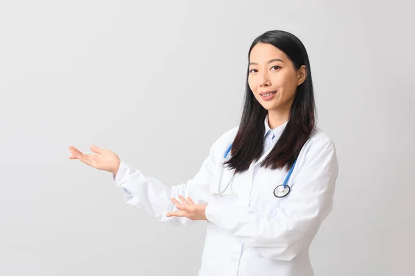 Kobieta Azji Lekarz Pokazując Coś Jasnym Tle — Zdjęcie stockowe