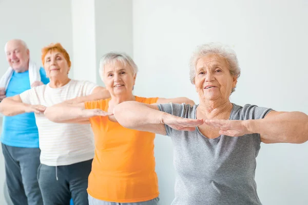 Elderly people exercising in gym