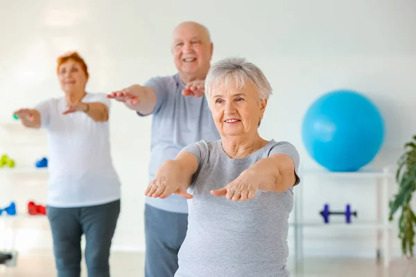 Elderly woman exercising in gym