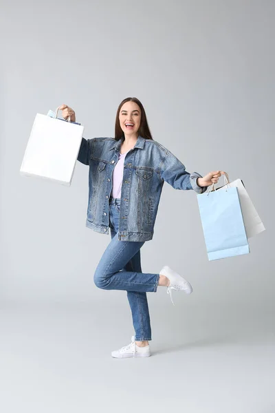 Mujer Joven Con Bolsas Compras Sobre Fondo Gris —  Fotos de Stock