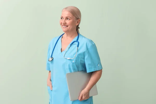 Volwassen Vrouwelijke Arts Met Laptop Kleur Achtergrond — Stockfoto