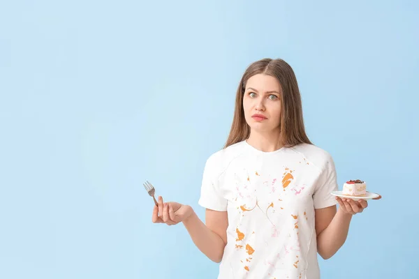 Unruhige Frau Schmutziger Kleidung Isst Dessert Auf Farbigem Hintergrund — Stockfoto