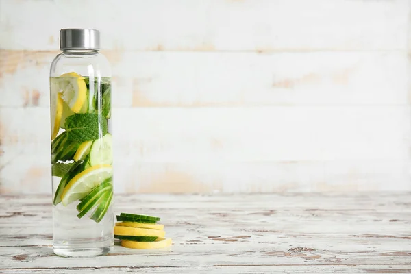 Bottle of infused cucumber water on table