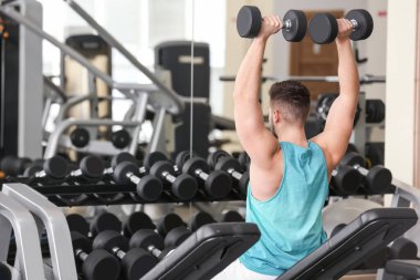 Spor salonunda Dambıl ile sportif genç adam eğitim
