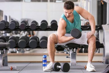 Spor salonunda Dambıl ile sportif genç adam eğitim