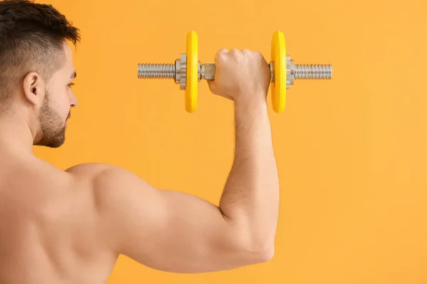 Joven Deportivo Entrenando Con Pesas Sobre Fondo Color —  Fotos de Stock