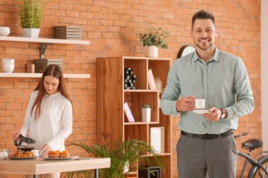 İşadamı ofiste kahve içiyor.