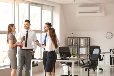 İş arkadaşları ofiste kahve içiyor.