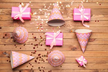 Ahşap arka planda parti şapkaları ve hediye kutuları