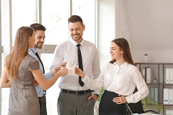 Colleagues drinking coffee in office