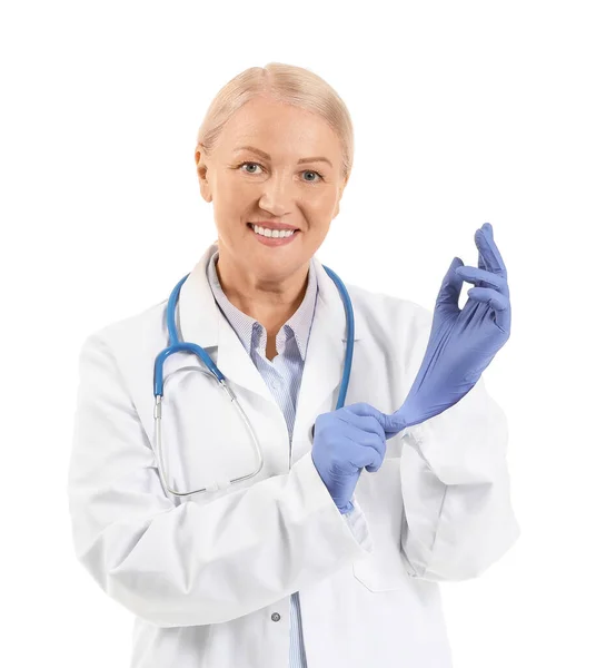 Reife Ärztin Zieht Gummihandschuhe Vor Weißem Hintergrund — Stockfoto