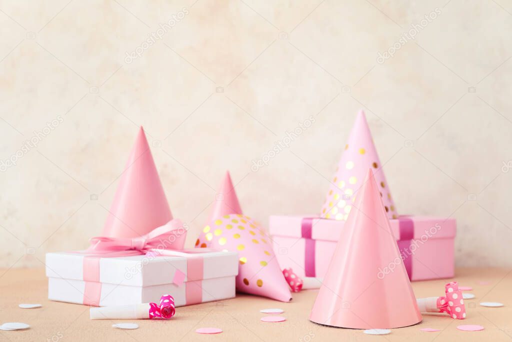 Party hats and gift boxes on light background
