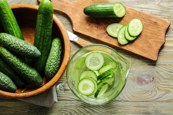 Jug of infused cucumber water on table
