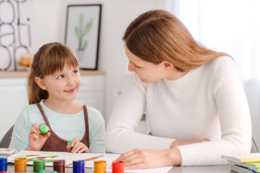 Çizim öğretmeni evde küçük bir kıza özel sanat dersleri veriyor.